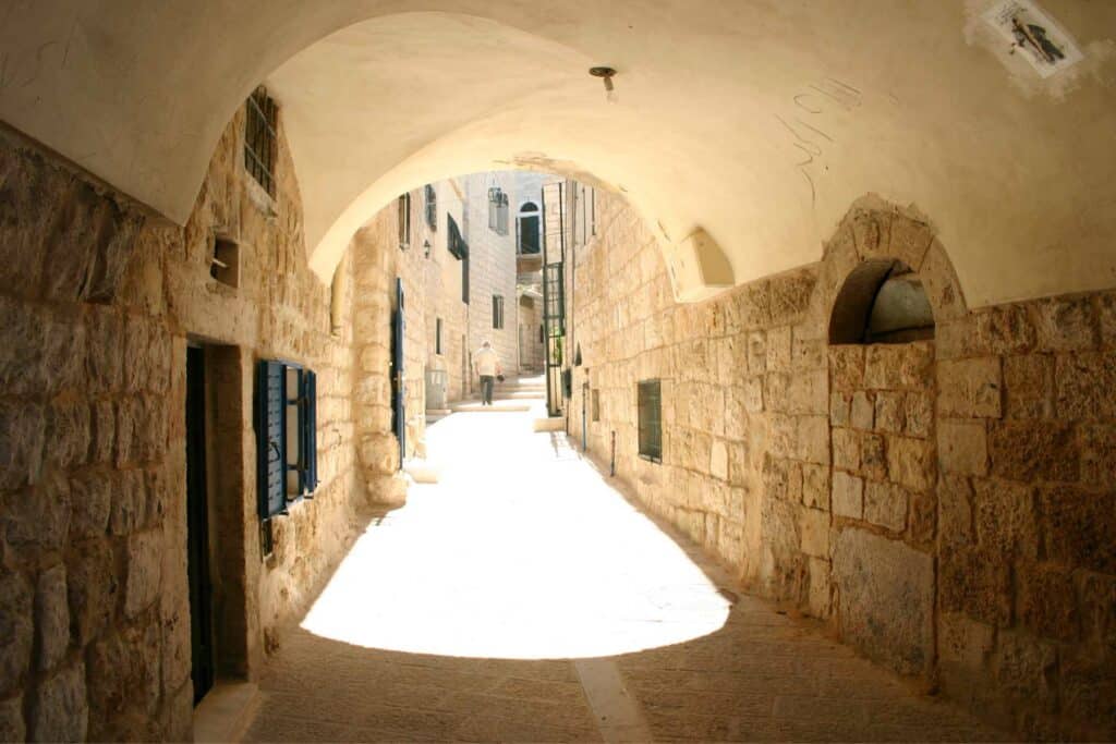 Ruelle voûtée de Bethléem baignée de lumière dans une ambiance sacrée et silencieuse.
