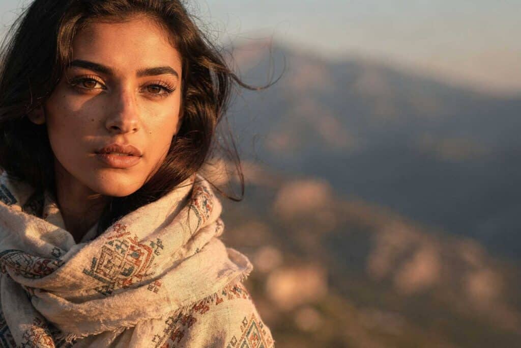 Jeune femme kabyle moderne à gauche de l’image, face aux montagnes, symbole d’amour et d’exil dans Houria, d’une rive à l’autre.
