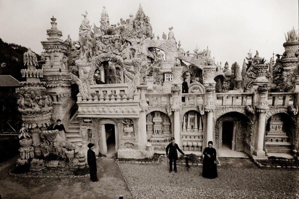 Ferdinand Cheval en uniforme de facteur et Philomène devant la façade ouest du Palais idéal à Hauterives, vers 1910