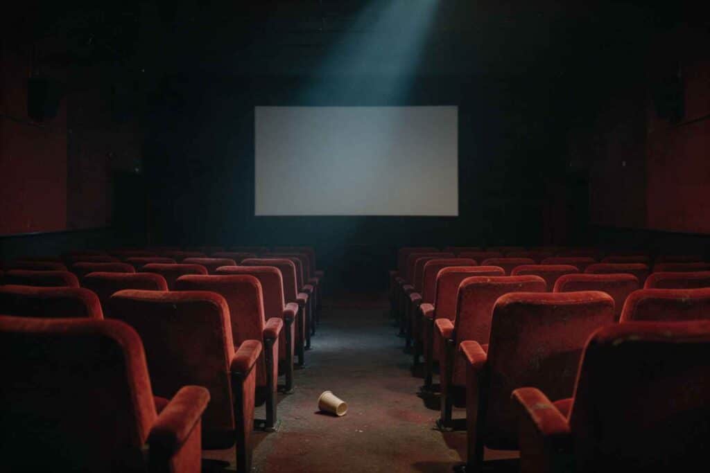 Salle de cinéma vide aux fauteuils rouges élimés, image symbolique de Viser juste d'Adèle Haenel