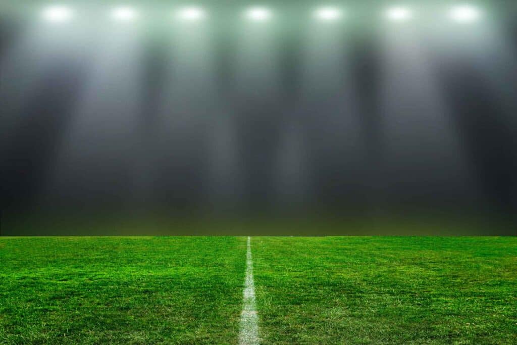 Pelouse de stade vide sous des projecteurs allumés dans la brume